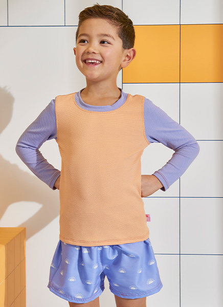 Boy wearing swim vest and shorts posing