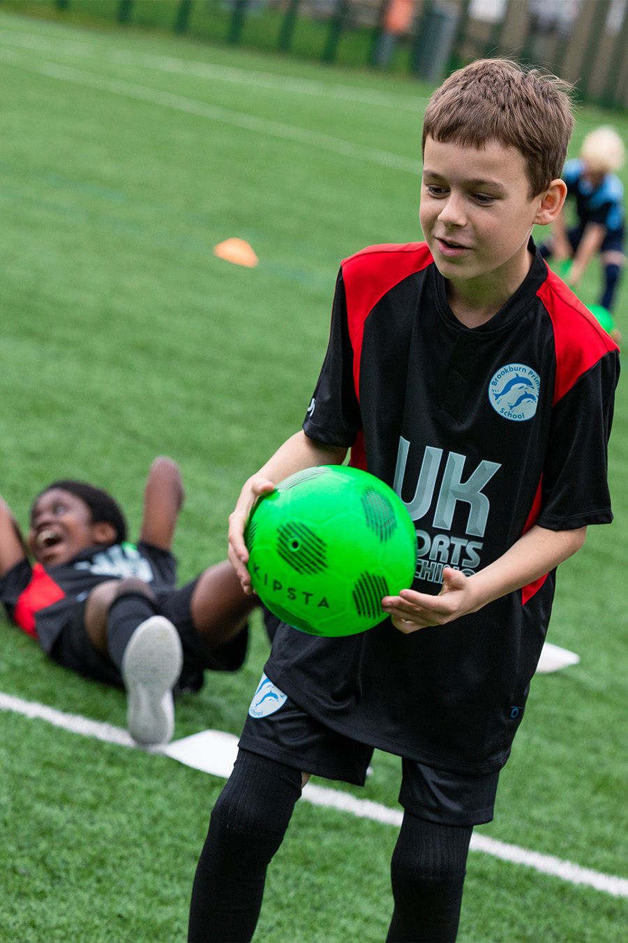 Boy holding football on field